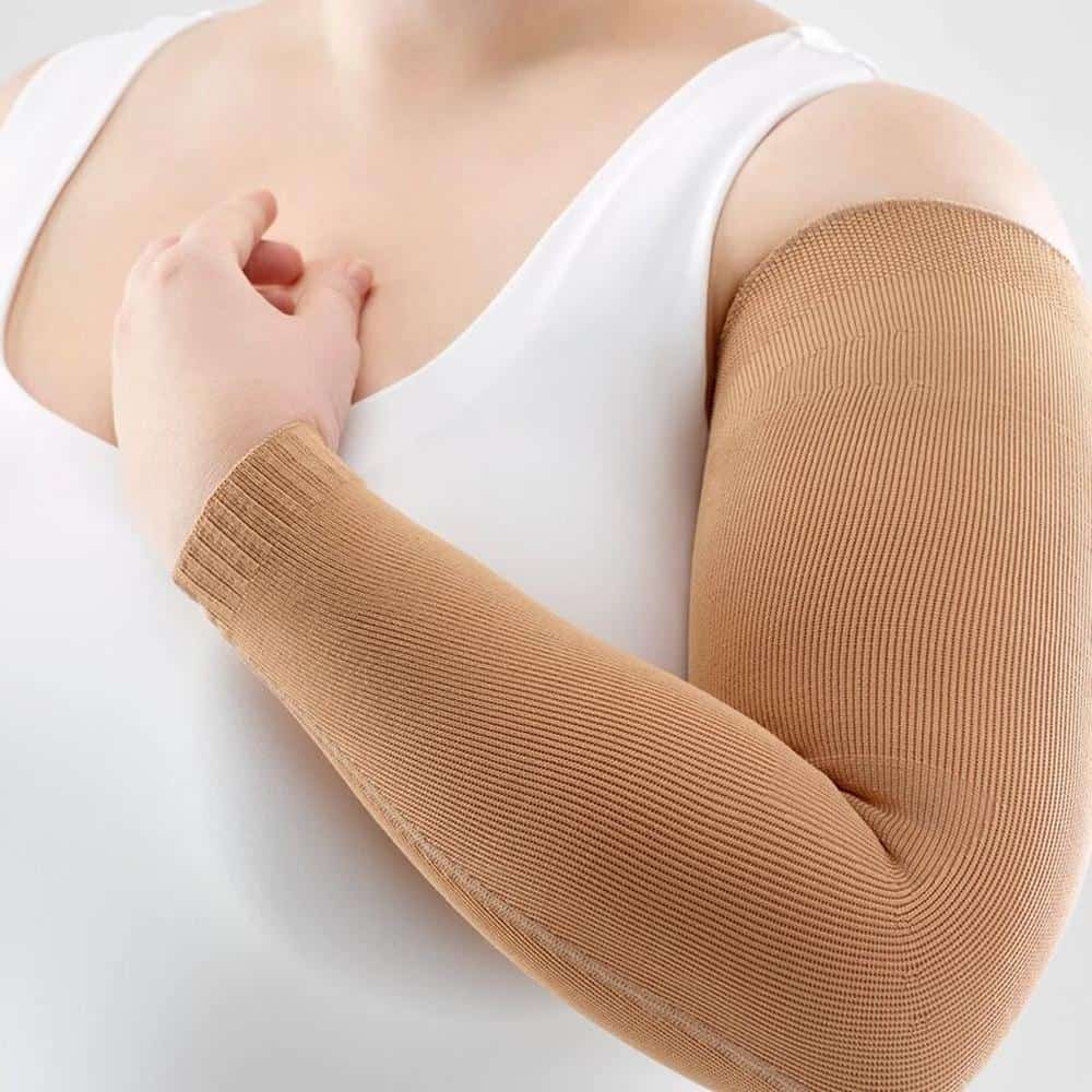VenoTrain® curaflow armkousen 3 Damesarm met elastische compressiekniebandage, beige kleur, op witte achtergrond.