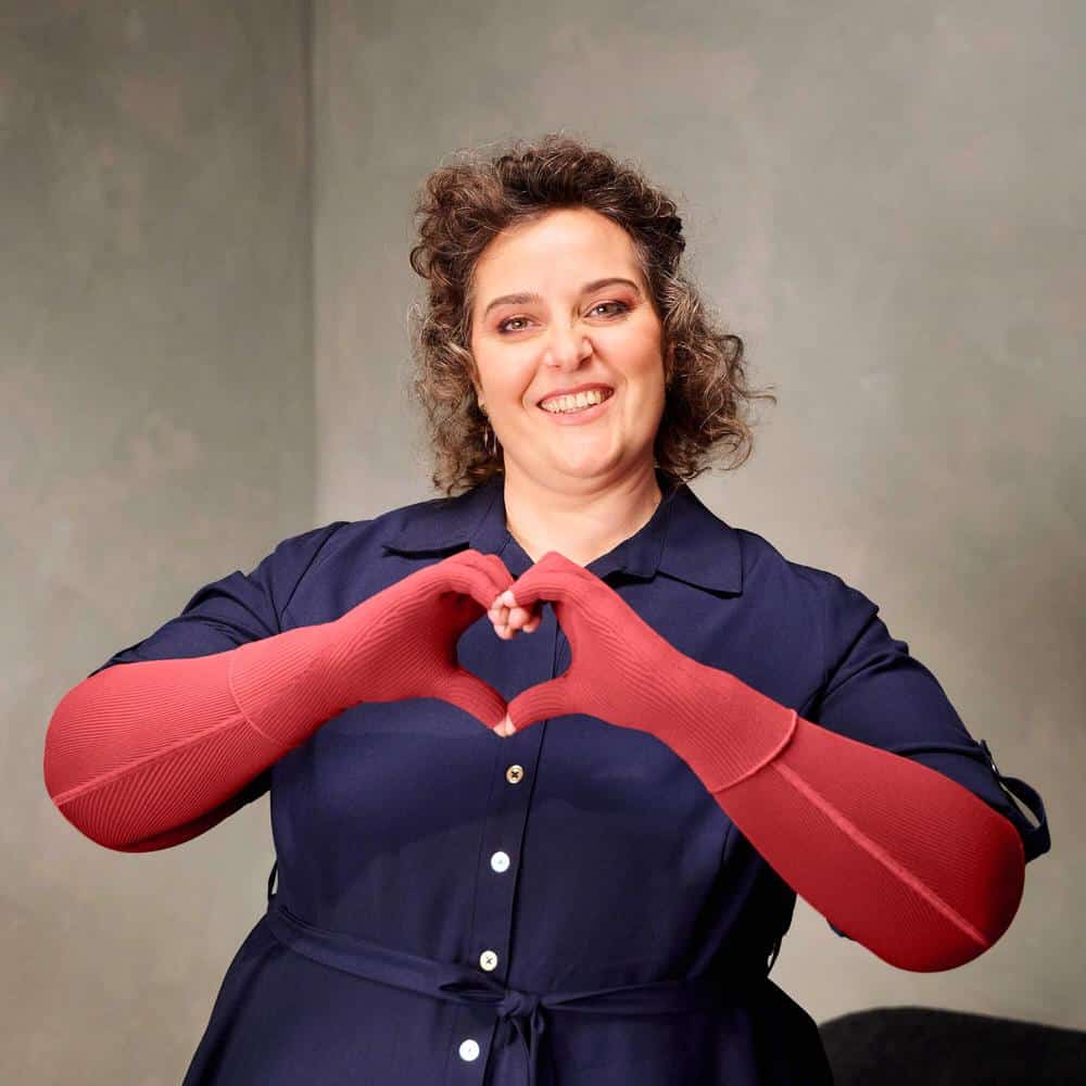VenoTrain® curaflow armkousen 2 FriskFysio nh vrouw maakt hartvorm met armen, glimlacht naar camera.