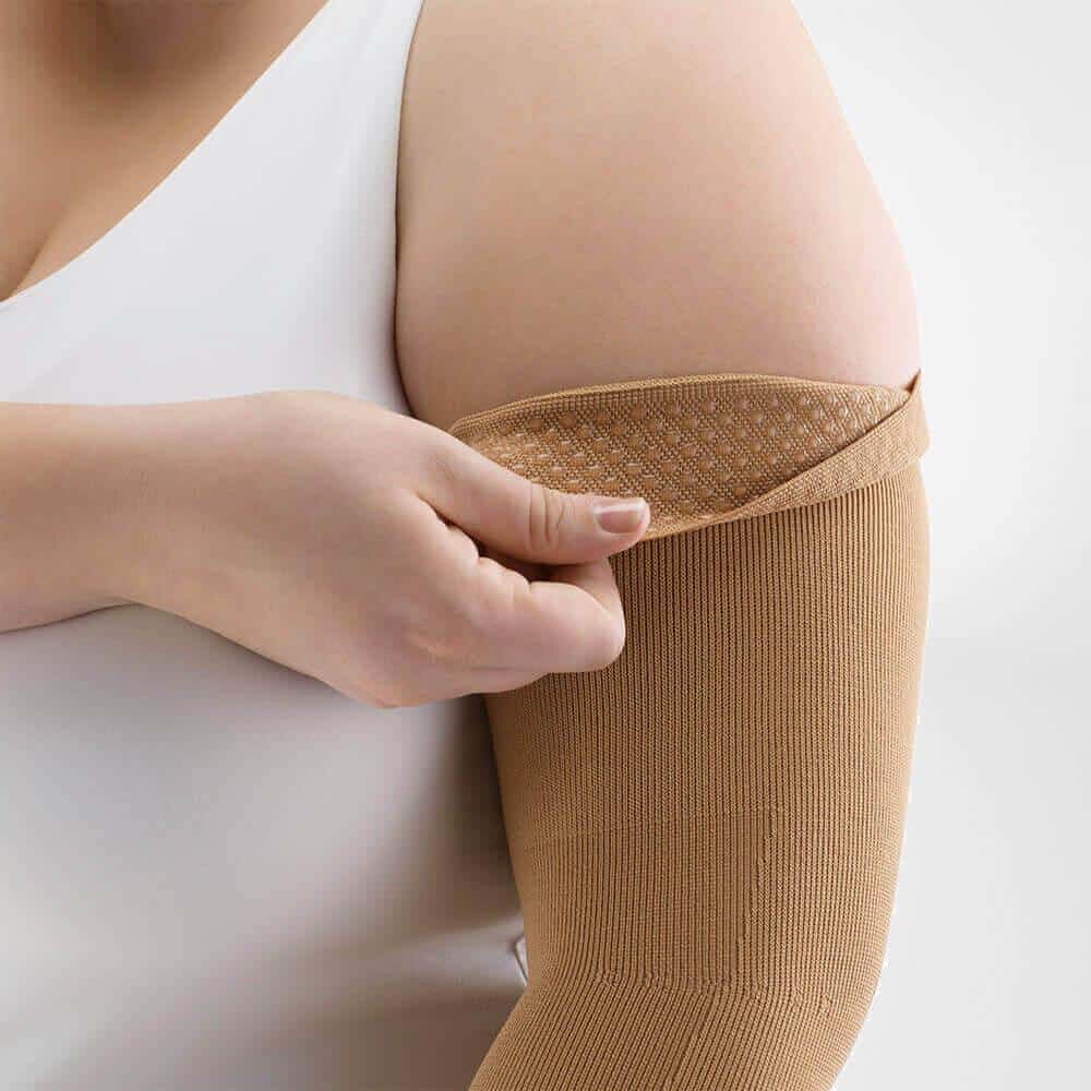 VenoTrain® curaflow armkousen 5 Vrouw heeft elastische kompres- arm- en schouderbandage aan, medische taping voor ondersteuning bij elleboog- en bovenarmgebied.