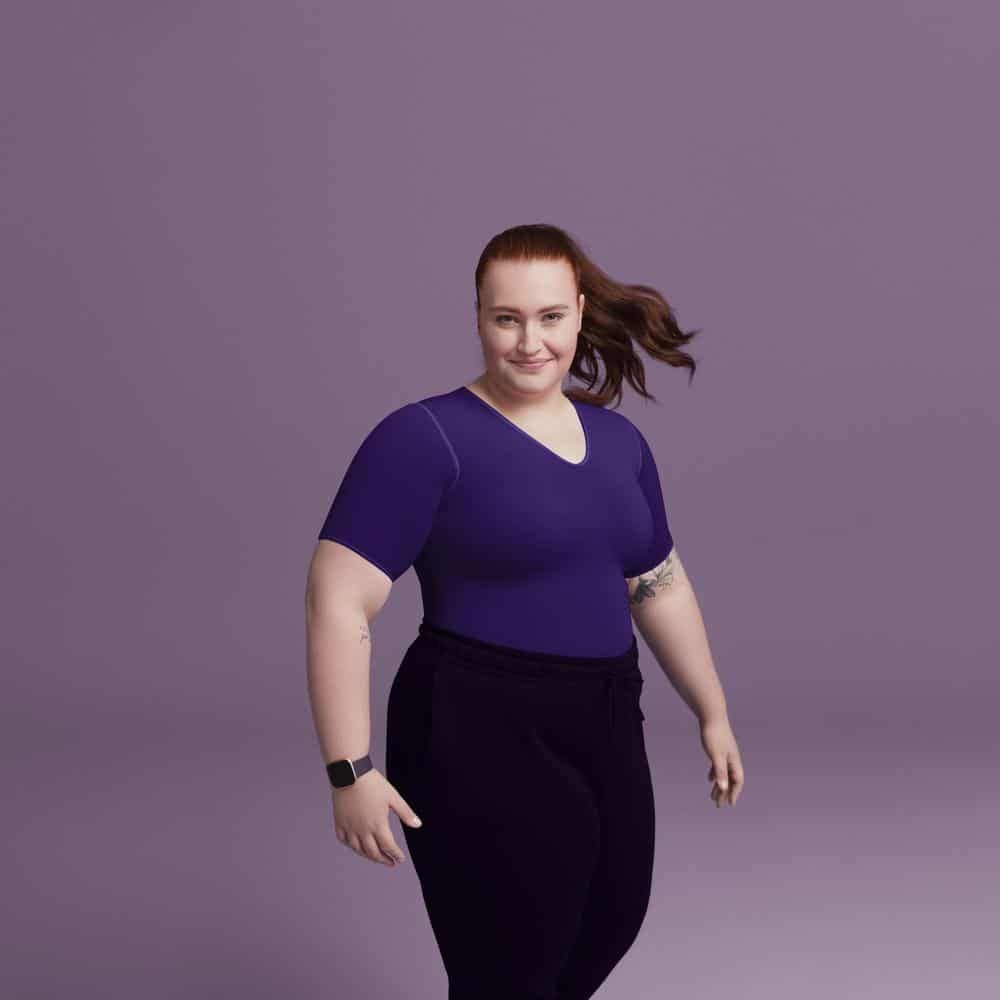 VenoTrain® curaflow thorax 2 Frisk Fysio afbeelding van een vrouw in paarse top en donkere broek, zelfverzekerd en actief poseert op een paarse achtergrond.